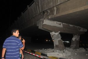 People take pictures of a collapsed bridge in Guayaquil, Ecuador, after a powerful earthquake hit the country on April 16, 2016. At least 28 people were killed when a powerful 7.8-magnitude earthquake struck Ecuador on Saturday, knocking down buildings in the country's largest city Guayaquil and cutting power in the capital Quito. The quake also rattled northern Peru and southern Colombia, according to authorities in those countries, although no casualties were reported. / AFP PHOTO / JOSE SANCHEZ LINDAO