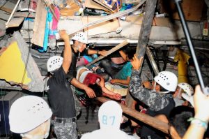 Rescue workers work to pull out survivors trapped in a collapsed building after a huge earthquake struck, in the city of Manta early on April 17, 2016. At least 41 people were killed when a powerful 7.8-magnitude earthquake struck Ecuador, destroying buildings and sending terrified residents dashing from their homes, authorities said late on April 16. / AFP PHOTO / API AND AFP PHOTO / Ariel Ochoa