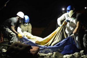 Rescue workers carry a corpse from earthquake rubbble in Pedernales, Ecuador on April 20, 2016.  The death toll from Ecuador's earthquake was set to rise sharply after authorities warned that 1,700 people were still missing and anger gripped families of victims trapped in the rubble. / AFP PHOTO / RODRIGO BUENDIA