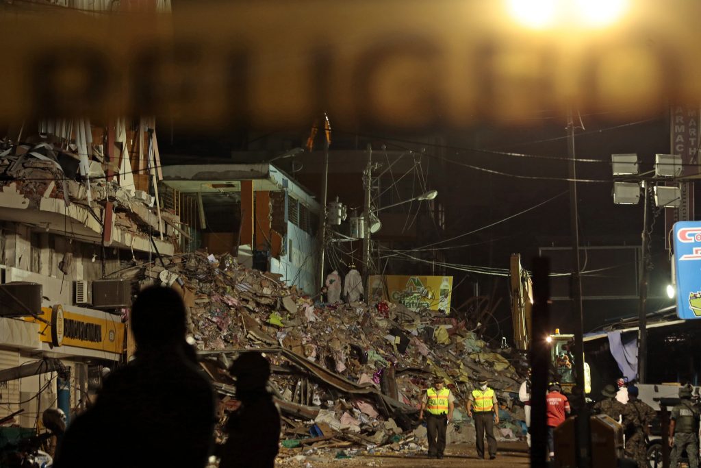 Firefighters wear white colored suits to care for the biological risk arising from the putrefaction of the corpses during the clean-up operations and rescue of the earthquake victims in Manta on April 20, 2016. The death toll from Ecuador's earthquake was set to rise sharply after authorities warned that 1,700 people were still missing and anger gripped families of victims trapped in the rubble. A 6.1-magnitude earthquake struck off the coast of Ecuador Wednesday, sowing new panic four days after a more powerful quake killed more than 525 people, with hundreds still missing. / AFP PHOTO / Juan Cevallos