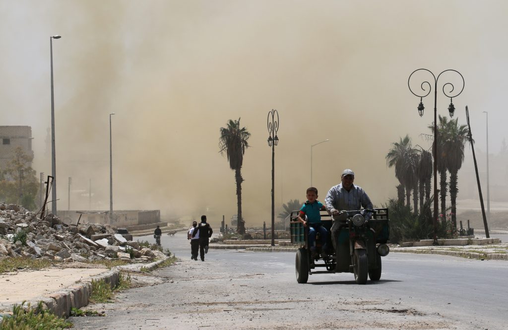 Syrians evacuate the area following an air strike on the rebel-held eastern Bab al-Nayrab neighbourhood of the northern Syrian city of Aleppo on April 26, 2016. Air strikes on rebel-held areas of Syria's second city Aleppo and a town to its west killed at least over a dozen people emergency workers said. / AFP PHOTO / AMEER ALHALBI