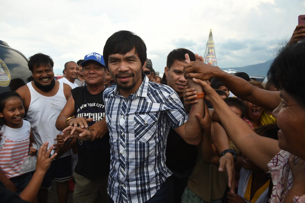 Philippine boxing icon Manny Pacquiao is mobbed bu supporters during a campaign sortie in Calamba town, Laguna province south of Manila on April 28, 2016. Pacquiao expressed shock on April 28 at President Benigno Aquino's claim that Islamic militants planned to kidnap him, and said the alleged plot should not have been made public. / AFP PHOTO / TED ALJIBE
