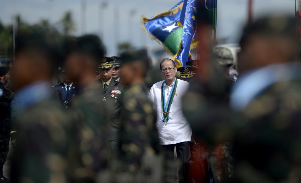 Philippine President Benigno Aquino (C) inspects troops during the Armed Forces of the Philippines (AFP) 80th anniversary celebration at Haribon Hangar, Air Force City, Clark Air Base, Pampanga, south of Manila on December 21, 2015. Philippine President Benigno Aquino promised on December 21 that 1.77 billion USD (83.9 billion pesos) allocated for military modernisation projects would be spent by 2017 as the country faces a territorial dispute with China. AFP PHOTO / NOEL CELIS / AFP PHOTO / NOEL CELIS