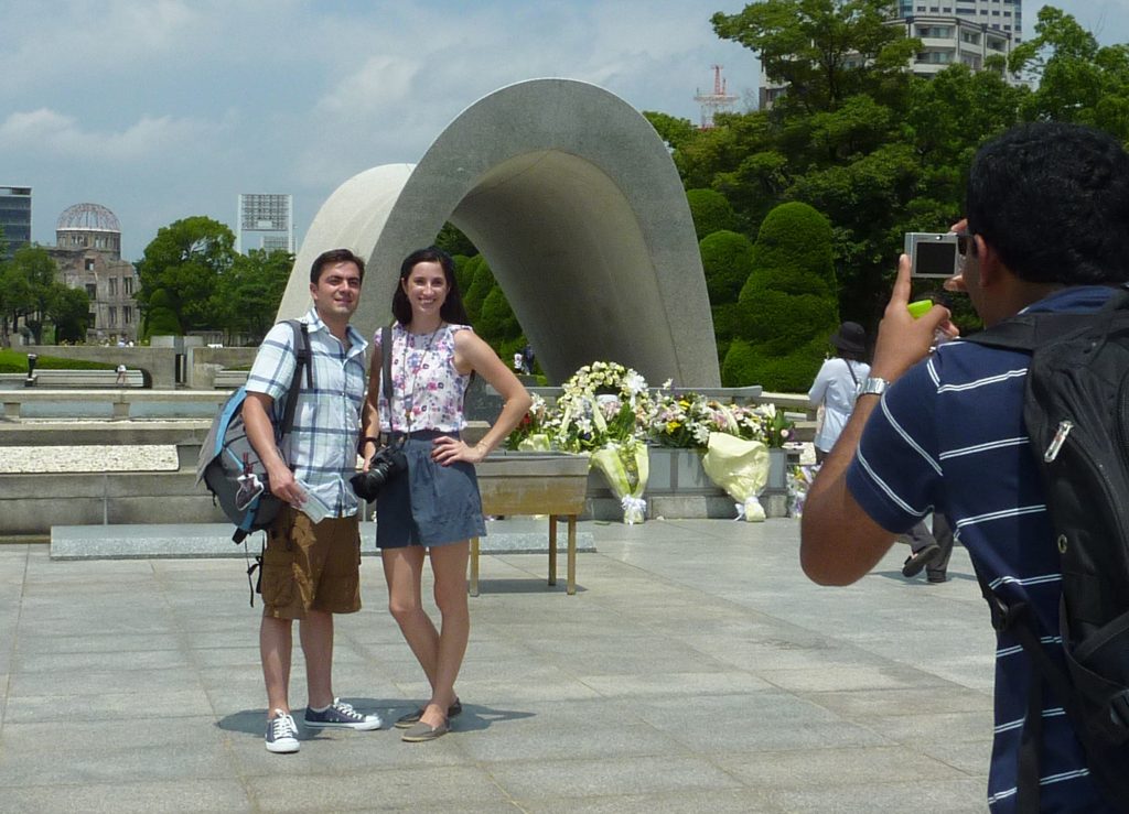 TO GO WITH Japan-US-nuclear-weapons-WWII,ADVANCER by Shingo Ito Foreign tourists pose for souvenir pictures in front of the altar for victims of the 1945 atomic bombing at Hiroshima's Peace Memorial Park in western Japan on August 1, 2010. Sixty-five years after a mushroom cloud rose over charred Hiroshima, the United States will for the first time send an envoy on August 6, 2010 to commemorate the bombing that rang in the nuclear age. AFP PHOTO / Shingo ITO / AFP PHOTO / SHINGO ITO