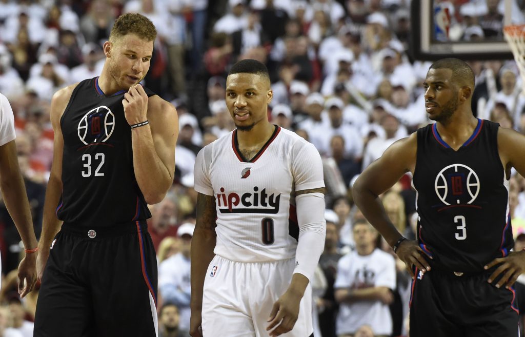 PORTLAND, OR - APRIL 23: Blake Griffin #32 of the Los Angeles Clippers has some words with Damian Lillard #0 of the Portland Trail Blazers as Chris Paul #3 of the Los Angeles Clippers looks on in the fourth quarter of Game Three of the Western Conference Quarterfinals during the 2016 NBA Playoffs at the Moda Center on April 23, 2016 in Portland, Oregon. The Blazers won the game 96-88. NOTE TO USER: User expressly acknowledges and agrees that by downloading and/or using this photograph, user is consenting to the terms and conditions of the Getty Images License Agreement. Steve Dykes/Getty Images/AFP