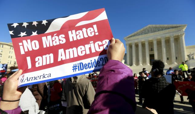 A protester holds a sign as immigrants and community leaders rally in front of the U.S. Supreme Court to mark the one-year anniversary of President Barack Obama's executive orders on immigration in Washington, in this file photo taken November 20, 2015. Reuters/Kevin Lamarque/Files 