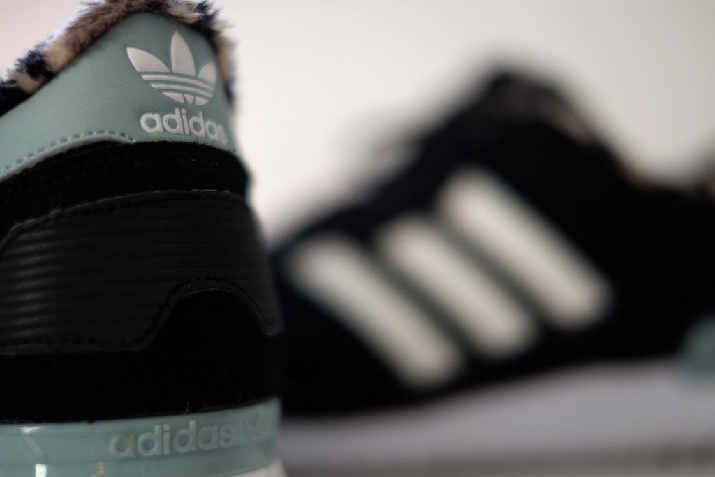 A logo of sporting goods manufacturer "Adidas" is seen on a training shoe in Oberhausen, western Germany on January 25, 2016.    / AFP PHOTO / PATRIK STOLLARZ