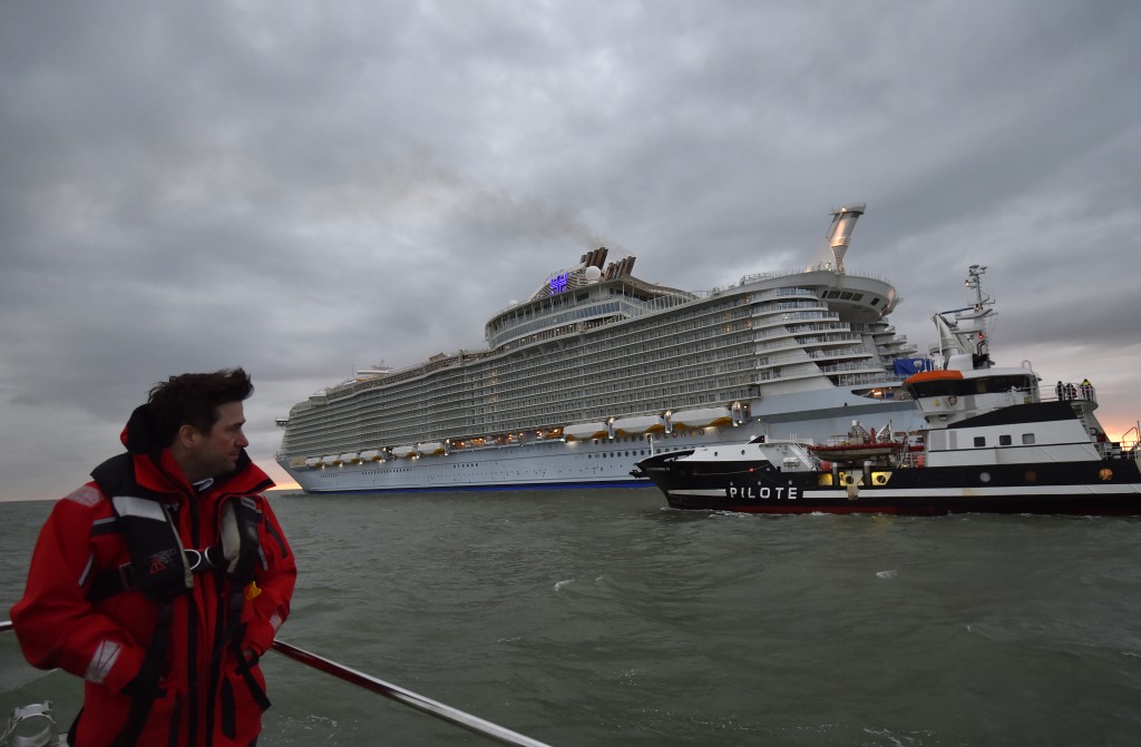 A Loire river pilot looks at the Harmony of the Seas cruise ship as it leaves the STX shipyard of Saint-Nazaire, western France, for a three-day offshore test, on March 10, 2016.  With a capacity of 6.296 passengers and 2.384 crew members, the Harmony of the Seas, built by STX France for the Royal Caribbean International, is the world's largest ship cruise.   / AFP PHOTO / LOIC VENANCE