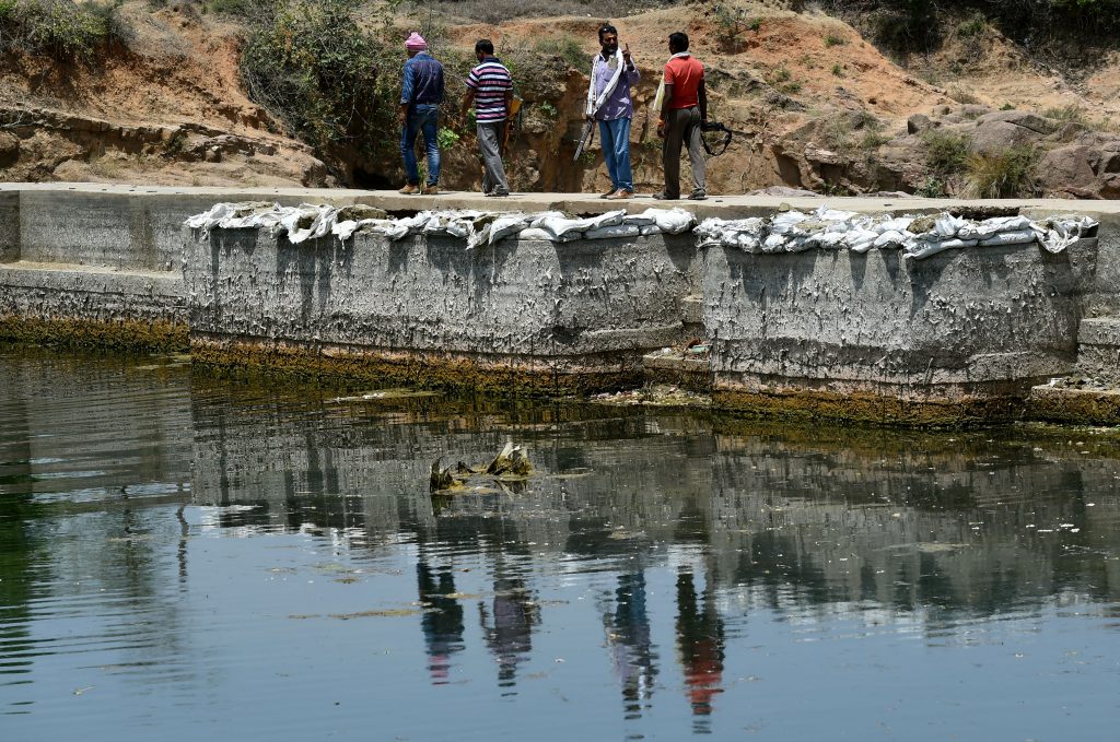 In this photograph taken on April 27, 2016, gunmen patrol at a water reservoir in Tikamgarh in the central Indian state of Madhya Pradesh. Armed men have been securing the Barighat dam for months against water thefts by desperate farmers from neighbouring state to ensure supply of potable water to thousands of residents of Tikamgarh district in Madhya Pradesh state. Tikamgarh is part of central India's parched Bundelkhand region -- consisting of 13 districts, half of which lie in neighbouring Uttar Pradesh state- which is reeling from years of below-par monsoon rains. Officials say the ground water level has receded more than 100 feet in past few years as the area has been receiving less than half of the average annual rains. / AFP PHOTO / MONEY SHARMA / TO GO WITH AFP STORY INDIA-WEATHER-DROUGHT,FOCUS BY JALEES ANDRABI