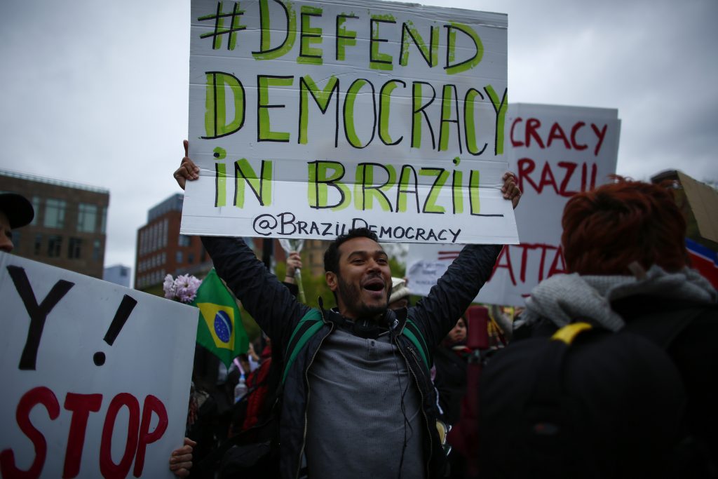 A supporter of the Brazilian president Dilma Rousseff, shouts slogans while participating in a May Day rally on May 1, 2016 in New York. Thousands of people attended May Day rallies organized by labor unions in cities across Latin America's biggest country, with Rousseff telling a crowd in the financial powerhouse Sao Paulo that she would "fight to the end." / AFP PHOTO / KENA BETANCUR