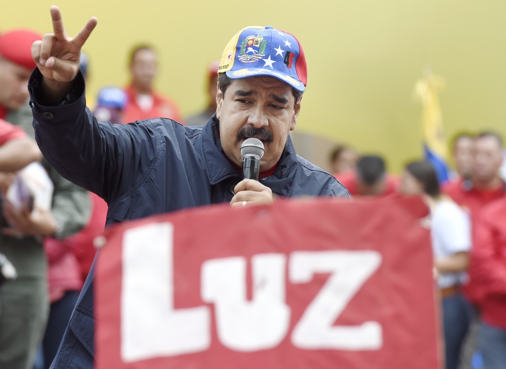 Venezuelan president Nicolas Maduro greets supporters during a march to mark International Workers' Day, in Caracas on May 1, 2016. / AFP PHOTO / JUAN BARRETO