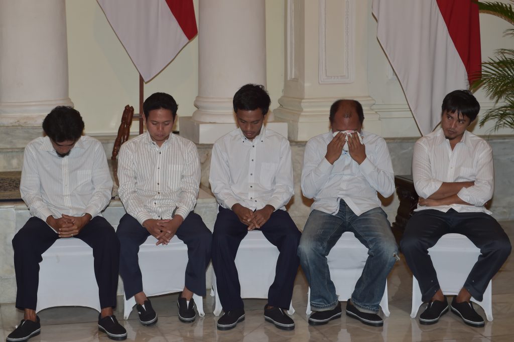 Indonesian sailors attend a ceremony to mark the hostages being handed over to thier families at the Foreign Ministry office in Jakarta on May 2, 2016, after ten Indonesian sailors held hostage by Abu Sayyaf Islamic militants returned home on May 1 after being freed in the southern Philippines, less than a week after the gunmen beheaded a Canadian captive. About five weeks after being abducted, the 10 tugboat crew turned up outside the house of the provincial governor on the remote Philippine island of Jolo. They flew back to Jakarta later the same day, arriving on a private plane at an air force base before being driven away in a minibus without speaking to reporters. / AFP PHOTO / ADEK BERRY