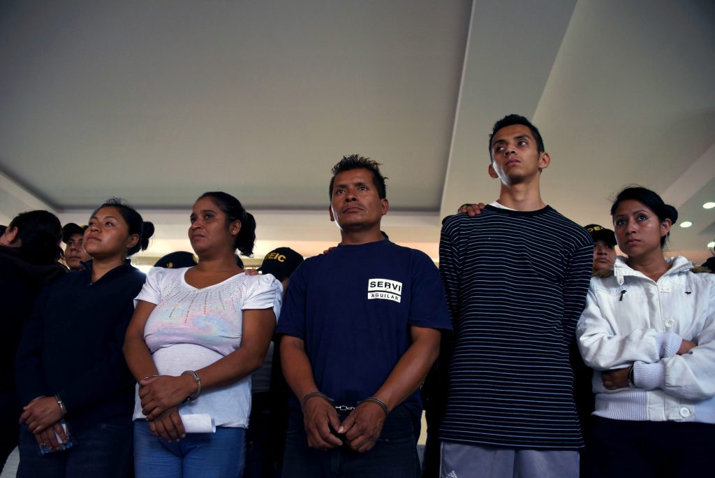 Some of 72 alleged members the "Barrio 18" gang, wait to be registered by the National Civil Police after being arrested on charges of extortion and murder in Guatemala City on May 2, 2016. Security forces on Monday launched raids on one of the biggest gangs in Guatemala, arresting 72 suspected members in different parts of the country, officials said. / AFP PHOTO / JOHAN ORDONEZ