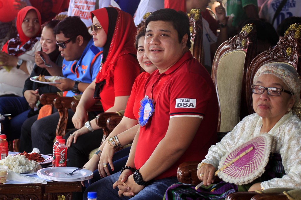 This photo taken on April 28, 2016 shows Shariff Aguak's mayoral candidate Sajid Ampatuan listening to speeches along with his mother Bai Laila Ampatuan (R) during a campaign rally in Shariff Aguak town, Maguindanao province, in the southern Philippine island of Mindanao. Walking off stage after a rock star-like performance and rapturous crowd reaction, Sajid Ampatuan oozes confidence that he will be elected mayor of a southern Philippine town despite facing charges of mass murder. His father, former provincial governor Andal Ampatuan, allegedly ordered his sons and their armed followers to kill 58 people in November 2009 in an attempt to stop a rival's election challenge.   / AFP PHOTO / MARK NAVALES / TO GO WITH AFP STORY PHILIPPINES-VOTE-LAW-CRIME,FOCUS BY FERDINANDH CABRERA