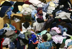 A woman picks through donated clothing and goods at a makeshift evacuee center in Lac la Biche, Alberta on May 5, 2016, after fleeing forest fires north of Fort McMurray. Raging wildfires pressed in on the Canadian oil city of Fort McMurray Thursday after more than 80,000 people were forced to flee, abandoning fire-gutted neighborhoods in a chaotic evacuation. No casualties have been reported from the monster blaze, which swept across Alberta's oil sands region driven by strong winds and hot, dry weather. / AFP PHOTO / Cole Burston