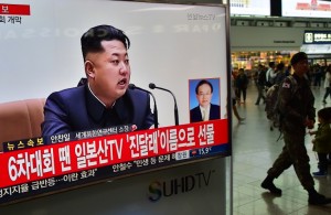 A South Korean soldier (R) walks past a television screen showing file footage of North Korean leader Kim Jong-Un, at a railway station in Seoul on May 6, 2016. North Korea raised the curtain on May 6 on its biggest political show for a generation, aimed at cementing the absolute rule of leader Kim Jong-Un and shadowed by the possibility of an imminent nuclear test. / AFP PHOTO / JUNG YEON-JE