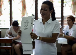 Philippine presidential candidate Senator Grace Poe shows her ballot paper to photographers as she casts her vote in the presidential elections at a polling center in Manila on May 9, 2016.  / AFP PHOTO / MOHD RASFAN