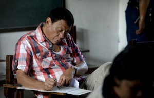Philippine presidential candidate and Davao City Mayor Rodrigo Duterte casts his vote at a voting precint at Daniel Aguinal National High School in Davao City, on the southern island of Mindanao on May 9, 2016.  Voting was underway in the Philippines on May 9 to elect a new president, with anti-establishment firebrand Rodrigo Duterte the shock favourite after an incendiary campaign in which he vowed to butcher criminals. / AFP PHOTO / NOEL CELIS