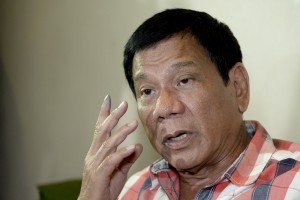 Philippines Presidential frontrunner and Davao City Mayor Rodrigo Duterte gestures as he is interviewed by reporters at a hotel in Davao City on the southern island of Mindanao on May 9, 2016. Anti-establishment firebrand Rodrigo Duterte was heading for a huge win in the Philippine presidential elections, according to a poll monitor, after an incendiary campaign dominated by his profanity-laced threats to kill criminals. / AFP PHOTO / NOEL CELIS