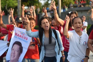 Supporters of Ferdinand Marcos Junior, a vice-presidential candidate and son of the late dictator Ferdinand Marcos, flash the "V" sign as they shout slogans during a protest at a park in Manila on May 11, 2016. Marcos is ranked second to the ruling party's vice-presidential candidate Leni Robredo in the vice-presidential race, according to the latest polling tally. / AFP PHOTO / TED ALJIBE