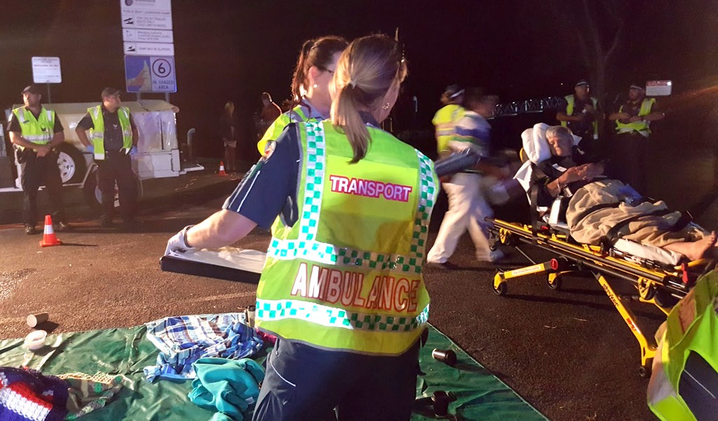 A handout photo taken by the Queensland Ambulance Service on May 11, 2016, and received on May 12, 2016, shows ambulance staff tending to more than 40 tourists, many of them Chinese, who were recovering in the town of 1770 after jumping into life rafts when the catamaran they were on caught fire in Australia. The Spirit of 1770 got into trouble 10 nautical miles off the coastal town of 1770 following a daytrip to Lady Musgrove Island on the Great Barrier Reef, apparently when a fire started in the engine room. / AFP PHOTO / AFP PHOTO AND QUEENSLAND AMBULANCE SERVICE / Queensland Ambulance Service / RESTRICTED TO EDITORIAL USE - MANDATORY CREDIT "AFP PHOTO / BMI" - NO MARKETING NO ADVERTISING CAMPAIGNS - DISTRIBUTED AS A SERVICE TO CLIENTS == NO ARCHIVE