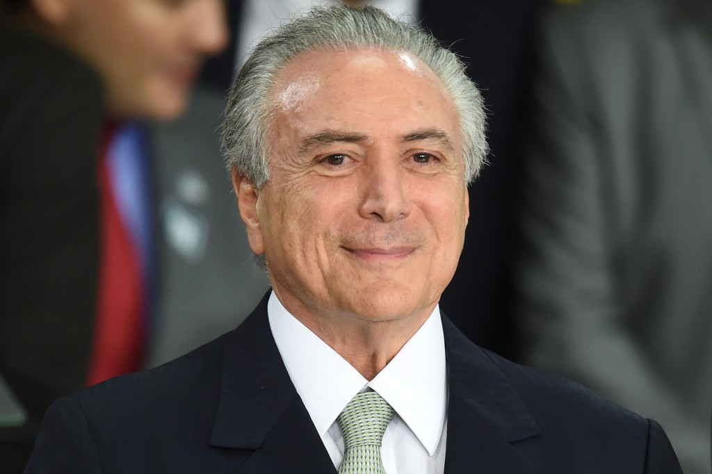 Brazilian acting President Michel Temer gestures during the inauguration ceremony of the new ministers at Planalto Palace, in Brasilia, on May 12, 2016. Brazilian President Dilma Rousseff was suspended Thursday to face an impeachment trial, ceding power to her vice president-turned-enemy Michel Temer, who quickly pivoted toward a more business-friendly government, naming a cabinet chosen to calm the markets after a paralyzing impeachment battle and steer the country out of its worst recession in decades.  / AFP PHOTO / EVARISTO SA / The erroneous mention[s] appearing in the metadata of this photo by MARCOS CORREA has been modified in AFP systems in the following manner: [EVARISOT SA] instead of [MARCOS CORREA] on byline. And Source AFP instead of BRAZILIAN VICE PRESIDENCY. Please immediately remove the erroneous mention[s] from all your online services and delete it (them) from your servers. If you have been authorized by AFP to distribute it (them) to third parties, please ensure that the same actions are carried out by them. Failure to promptly comply with these instructions will entail liability on your part for any continued or post notification usage. Therefore we thank you very much for all your attention and prompt action. We are sorry for the inconvenience this notification may cause and remain at your disposal for any further information you may require.