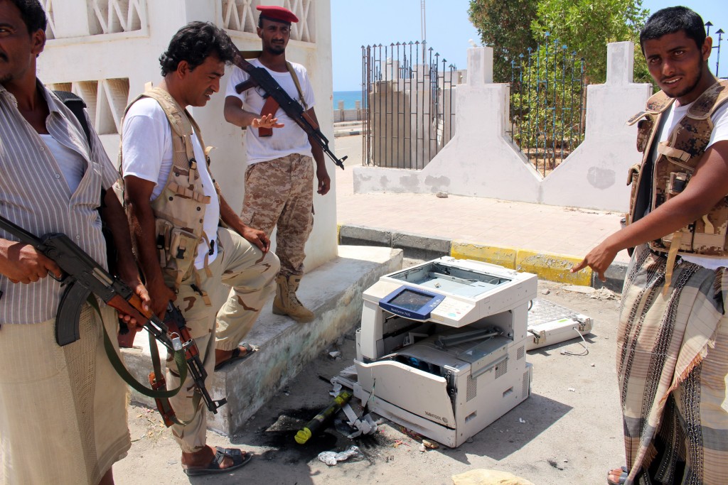 Yemeni soldiers stand next to a photocopier, they believed was carrying explosives, outside a public security camp following a reported suicide attack in the southeastern Yemeni port of Mukalla on May 15, 2016. / AFP PHOTO / STRINGER