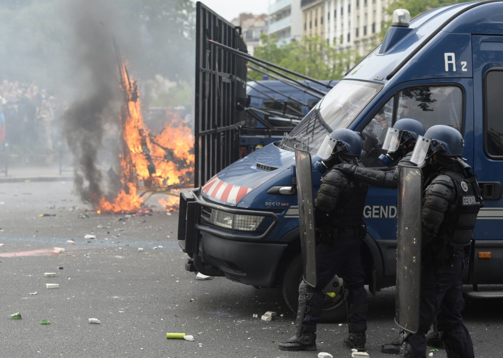 French riot police officers stand guard next to a burning barricade, during a protest against the government's labour market reforms in Paris, on May 26, 2016. The French government's labour market proposals, which are designed to make it easier for companies to hire and fire, have sparked a series of nationwide protests and strikes over the past three months.    AFP PHOTO / ALAIN JOCARD / AFP PHOTO / ALAIN JOCARD