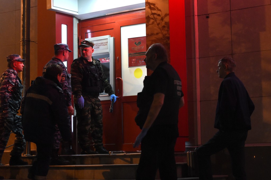 Russian police search a bank that was the scene of a hostage taking in Moscow on May 18, 2016. Russian special forces shot down a man who had taken hostages in a Moscow bank on Wednesday night. / AFP PHOTO / VASILY MAXIMOV