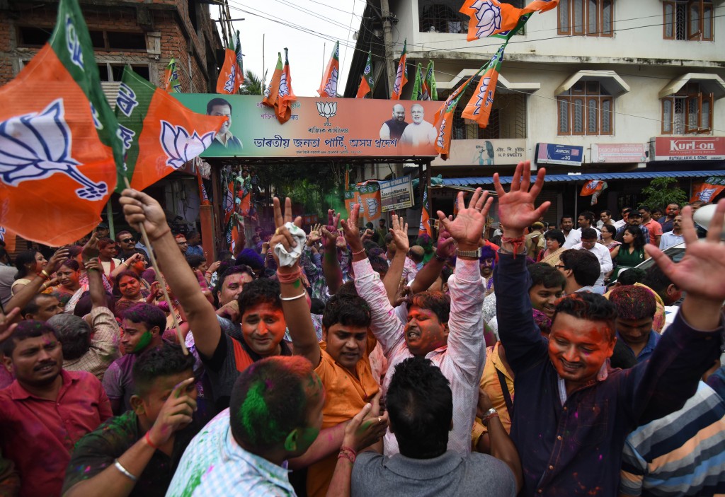Indian Bharatiya Janata Party (BJP) supporters celebrate after winning a majority in the Assam state assembly elections in Guwahati on May 19, 2016. India's ruling Bharatiya Janata Party claimed victory in Assam elections May 19, marking the first time the Hindu nationalist party has won control of a state in the country's restive northeast. / AFP PHOTO / Biju BORO