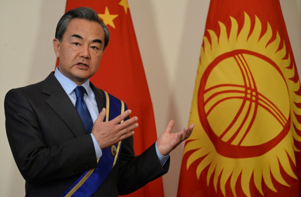 Chinese Foreign Minister Wang Yi gestures after receiving the Order of Danaker from Kyrgyz President Almazbek Atambayev (not pictured) during their meeting at the Ala-Archa state residence in Bishkek on 22 May, 2016. Chinese Foreign Minister Wang Yi is on an official visit to Kyrgyzstan. / AFP PHOTO / VYACHESLAV OSELEDKO