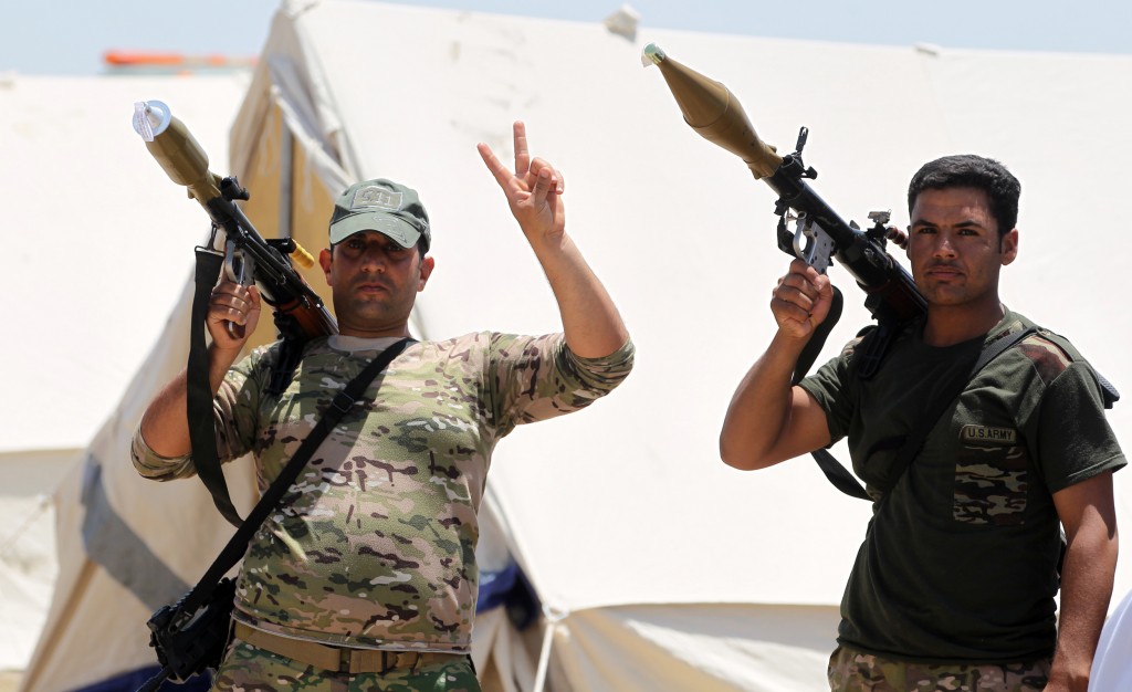 Members of the Iraqi security forces pose for a picture as they gather on the outskirts of Fallujah as they prepare an operation aimed at retaking the city from the Islamic State (IS) group, on May 22, 2016. Iraqi forces have in recent days been massing around Fallujah, a city which lies only 50 kilometres west of Baghdad and which has been out of government control since January 2014. / AFP PHOTO / AHMAD AL-RUBAYE