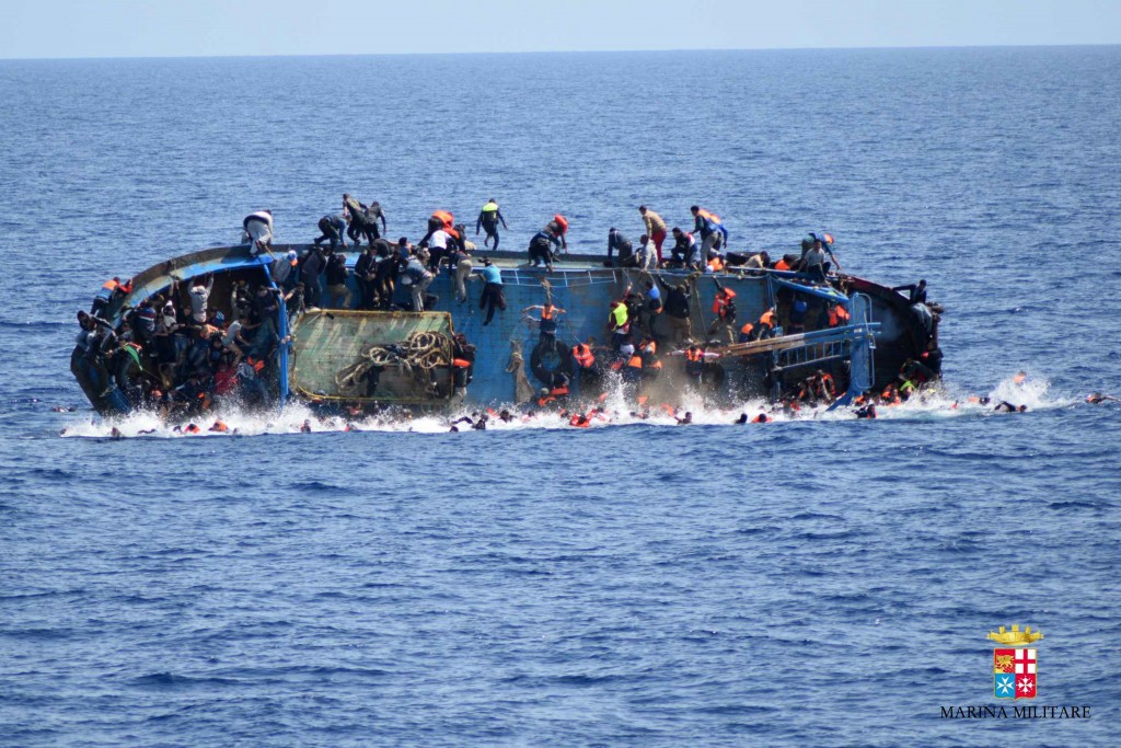 This handout picture released on May 25, 2016 by the Italian Navy (Marina Militare) shows the shipwreck of an overcrowded boat of migrants off the Libyan coast today. At least seven migrants have drowned after the heavily overcrowded boat they were sailing on overturned, the Italian navy said. The navy said 500 people had been pulled to safety and seven bodies recovered, but rescue operations were continuing and the death toll could rise. The navy's Bettica patrol boat spotted "a boat in precarious conditions off the coast of Libya with numerous migrants aboard," it said in a statement. / AFP PHOTO / MARINA MILITARE AND AFP PHOTO / STR / RESTRICTED TO EDITORIAL USE - MANDATORY CREDIT "AFP PHOTO / MARINA MILITARE" - NO MARKETING NO ADVERTISING CAMPAIGNS - DISTRIBUTED AS A SERVICE TO CLIENTS