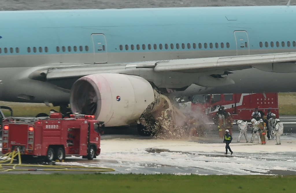A Korean Air Boeing 777 is seen on a runway in Tokyo's Haneda Airport on May 27, 2016. About 300 passengers and crew members were evacuated from the plane after one of the engines caught fire, official said on May 27. / AFP PHOTO / KAZUHIRO NOGI