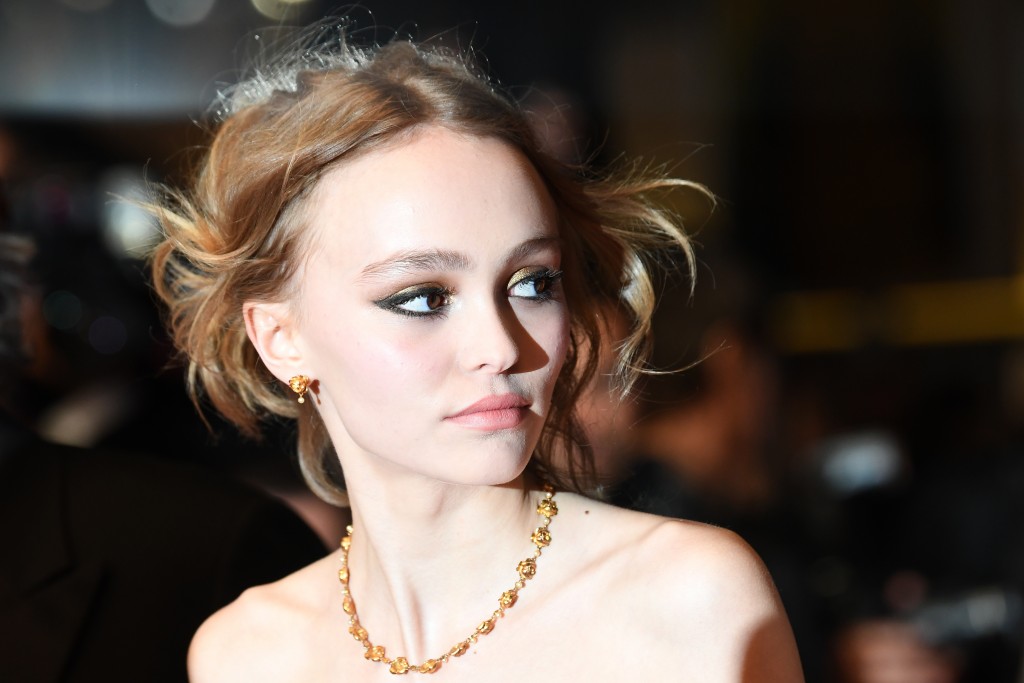 (FILES) This file photo taken on May 13, 2016 shows French-US actress Lily-Rose Depp arriving for the screening of the film "La Danseuse (The Dancer)" at the 69th Cannes Film Festival in Cannes, southern France. The daughter of Oscar-nominated star Johnny Depp took to social media on Sunday to defend her father, after his wife accused him of abuse and filed for divorce. Lily-Rose Depp posted a photo on Instagram apparently showing herself as a baby, with Johnny Depp holding her hands and helping her walk. / AFP PHOTO / ANNE-CHRISTINE POUJOULAT
