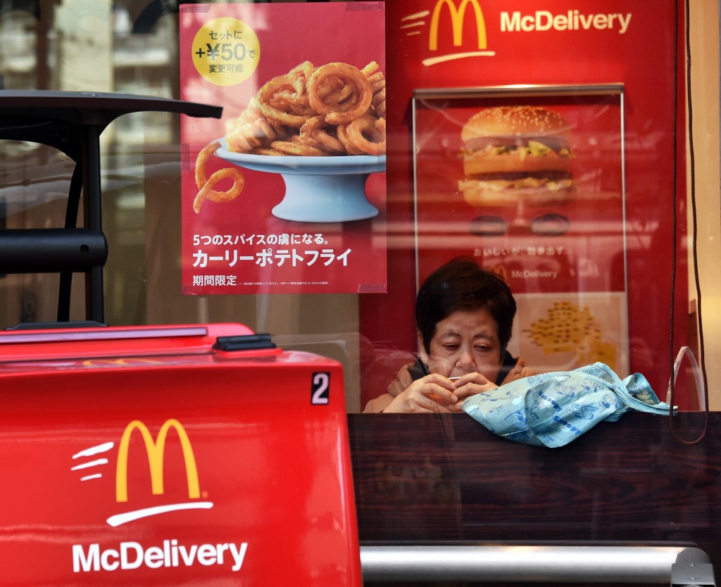 A customer sits inside a McDonald's fast-food restaurant in Tokyo on January 9, 2015. A Japanese woman discovered fragments of "dental material" in a McDonald's burger in 2014, the food chain said on January 9, the latest in a series of food contamination woes for the fast-food giant.    AFP PHOTO / Yoshikazu TSUNO / AFP PHOTO / YOSHIKAZU TSUNO
