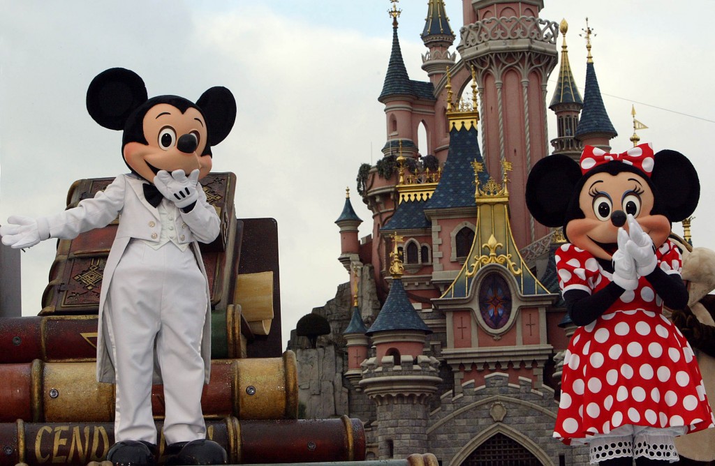 Euro Disney employees wearing Mickey Mouse and Minnie costums parade 18 November 2003 while celebrating the famous mouse's 75 birthday at Disneyland in Marne-la-Vallee, east of Paris. US Walt Disney's most famous round-eared creation, whose face and silhouette are familiar to generations of children across the world, first appeared on November 18 1928 in the animated short film "Steamboat Willie". / AFP PHOTO / MEHDI FEDOUACH