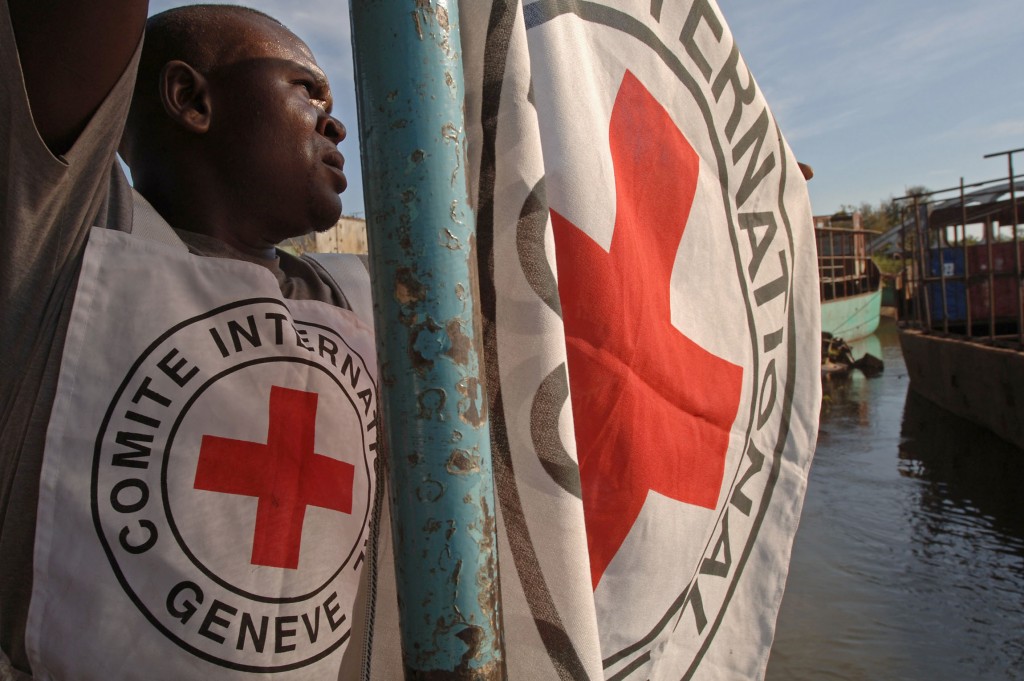 A Red Cross worker attaches a flag to a boat, 07 May 2006, in Bukama, north Katanga. The Red Cross will start delivering aid to returning families, who were displaced during fighting between Mai Mai rebels and the Congolese Army, at the east coast of Lake Upemba in the coming days. AFP PHOTO/LIONEL HEALING / AFP PHOTO / LIONEL HEALING