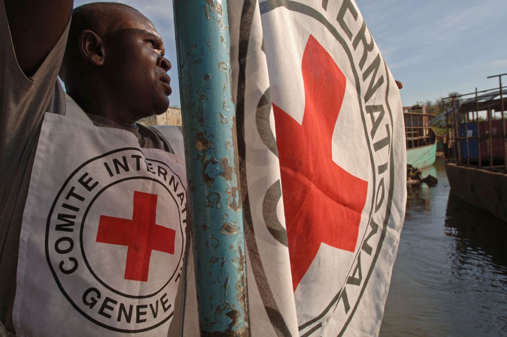 A Red Cross worker attaches a flag to a boat, 07 May 2006, in Bukama, north Katanga. The Red Cross will start delivering aid to returning families, who were displaced during fighting between Mai Mai rebels and the Congolese Army, at the east coast of Lake Upemba in the coming days.   AFP PHOTO/LIONEL HEALING / AFP PHOTO / LIONEL HEALING