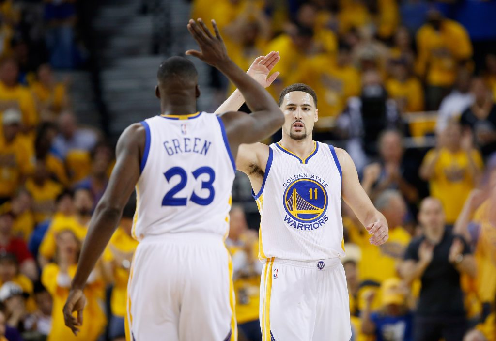 OAKLAND, CA - MAY 01: Klay Thompson #11 of the Golden State Warriors high-fives Draymond Green #23 during the first quarter against the Portland Trail Blazers during Game One of the Western Conference Semifinals for the 2016 NBA Playoffs at ORACLE Arena on May 01, 2016 in Oakland, California. NOTE TO USER: User expressly acknowledges and agrees that, by downloading and or using this photograph, User is consenting to the terms and conditions of the Getty Images License Agreement.   Ezra Shaw/Getty Images/AFP