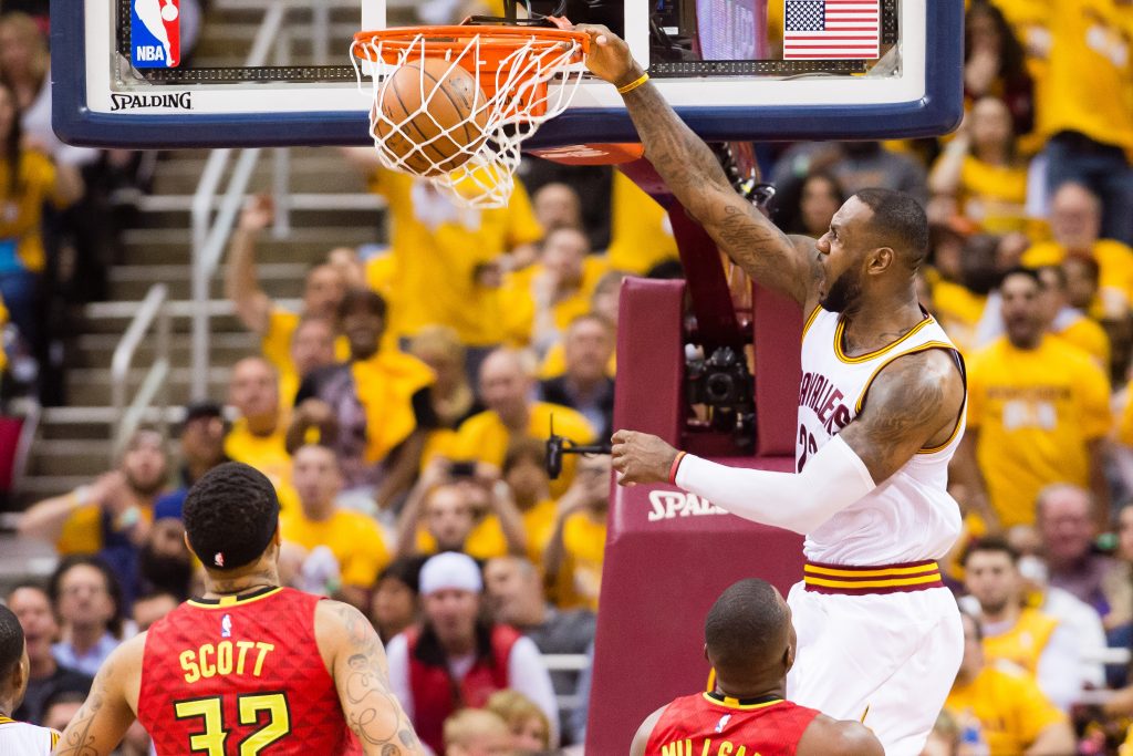 CLEVELAND, OH - MAY 2: LeBron James #23 of the Cleveland Cavaliers dunks over Mike Scott #32 and Paul Millsap #4 of the Atlanta Hawks during the second half of the NBA Eastern Conference semifinals at Quicken Loans Arena on May 2, 2016 in Cleveland, Ohio. The Cavaliers defeated the Hawks 104-93. NOTE TO USER: User expressly acknowledges and agrees that, by downloading and or using this photograph, User is consenting to the terms and conditions of the Getty Images License Agreement.   Jason Miller/Getty Images/AFP
