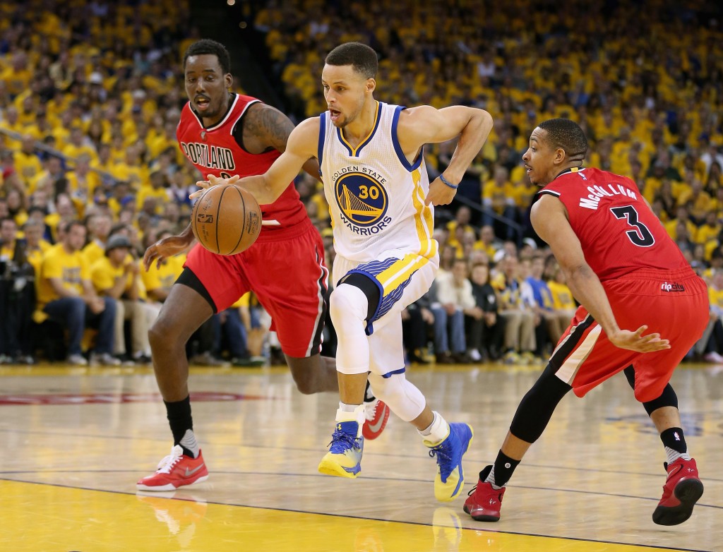 OAKLAND, CA - MAY 11: Stephen Curry #30 of the Golden State Warriors dribbles between Al-Farouq Aminu #8 and C.J. McCollum #3 of the Portland Trail Blazers during Game Five of the Western Conference Semifinals during the 2016 NBA Playoffs on May 11, 2016 at Oracle Arena in Oakland, California. NOTE TO USER: User expressly acknowledges and agrees that, by downloading and or using this photograph, User is consenting to the terms and conditions of the Getty Images License Agreement. Ezra Shaw/Getty Images/AFP