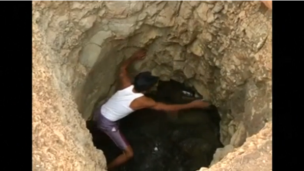 A labourer from lower-caste Dalit community digs up a well after being denied permission to draw water from the well of an upper-caste man in India's western Maharashtra state(photo grabbed from Reuters video) 