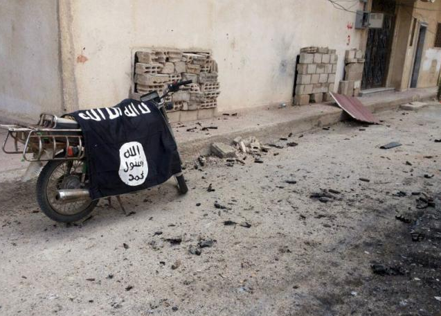  A flag belonging to the Islamic State fighters is seen on a motorbike after forces loyal to Syria's President Bashar al-Assad recaptured the historic city of Palmyra, in Homs Governorate in this handout picture provided by SANA on March 27, 2016. Reuters/SANA/Handout via Reuters 