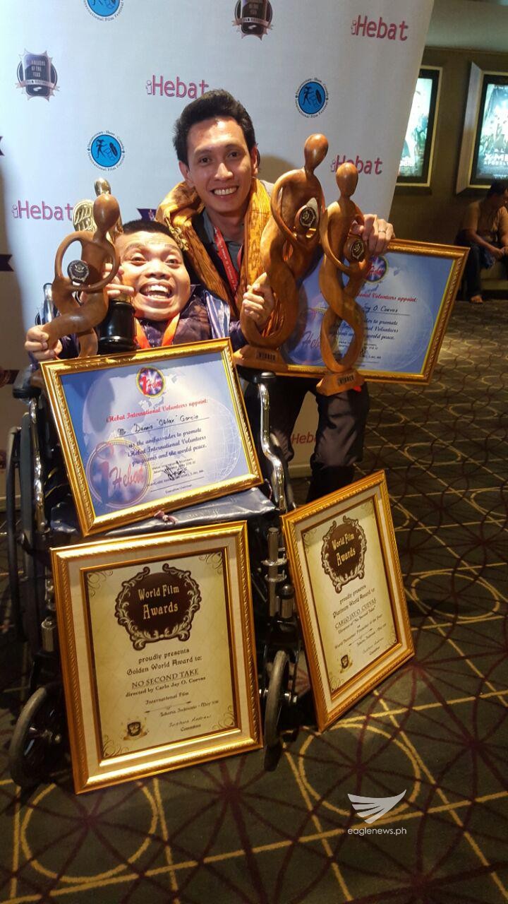 "Walang Take Two" director Carlo Jay Ortega Cuevas and actor Dennis "Oblax" Garcia hold the awards and plaques received by the INCinema produced film at the World Film Awards in Jakarta, Indonesia. (Eagle News Service)