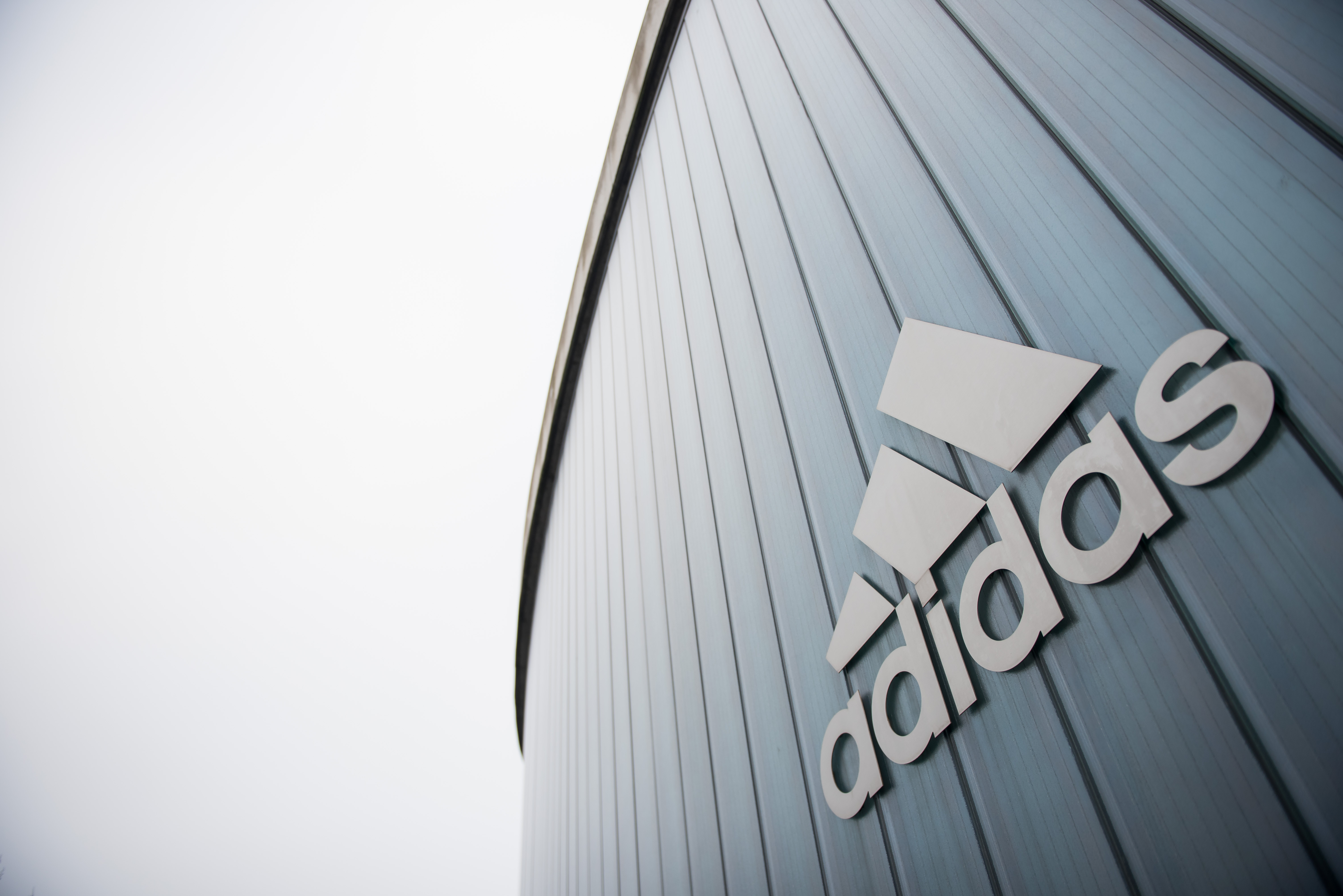 The logo of German sport brand Adidas is pictured on an Outlet Center in Herzogenaurach on January 25, 2016.  / AFP PHOTO / LUKAS BARTH
