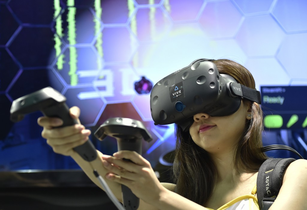 A model demonstrates the HTC Vive visual reality (VR) headset during the annual Computex computer exhibition in Taipei on May 31, 2016. More then 5,000 booths from thirty countries take part in COMPUTEX Show between May 31 to June 4. / AFP PHOTO / SAM YEH