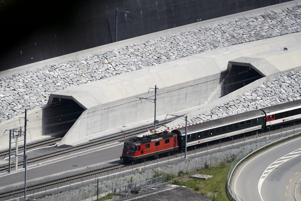 A train makes its way at the north entrance of the new Gotthard Base Tunnel the world's longest train tunnel on the eve of its opening ceremony on May 31, 2016 in Erstfeld. The new Gotthard Base Tunnel (GBT) is set to become the world's longest railway tunnel when it opens on June 1.The 57-kilometre (35.4-mile) tunnel, which runs under the Alps, was first conceived in sketch-form in 1947 but construction began 17 years ago. / AFP PHOTO / FABRICE COFFRINI