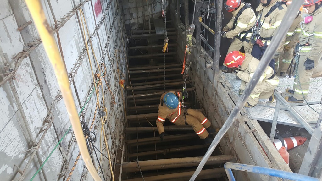 This handout photo released by Namyangju Fire Station shows South Korean rescue members going down to an underground to search for victims after an explosion -- possibly of an oxygen tank -- at a subway construction site in the city of Namyangju, east of Seoul, on June 1, 2016. Four workers were killed and 10 others injured in a collapse at a subway construction site near the South Korean capital Seoul, the fire department said. / AFP PHOTO / Namyangju Fire Station / NAMYANGJU FIRE STATION
