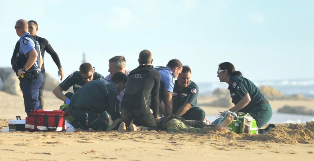 A photo taken on 31 May, 2016, shows ambulance and police officers helping a critically injured surfer after a shark ripped off his leg in an attack in Australia's west with witnesses recounting how "all hell broke loose" as his board was snapped in half. The attack happened at Falcon Beach, a suburb south of Perth, not long after Surf Life Saving WA, a volunteer non-profit organisation, tweeted that a shark, believed to be a great white, had been sighted in the area. / AFP PHOTO / MANDURAH MAIL / MARTA PASCUAL JUANOLA